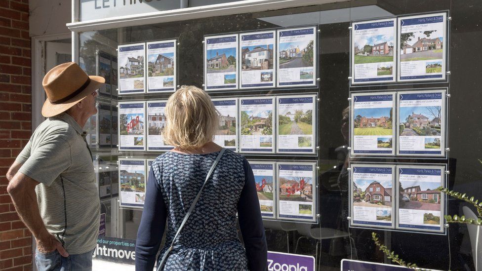 People looking at estate agent window