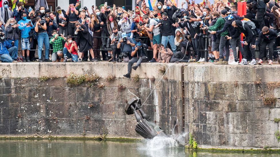 The statue of 17th century slave trader Edward Colston falls into the water after protesters pulled it down and pushed into the docks, during a protest against racial inequality in the aftermath of the death in Minneapolis police custody of George Floyd, in Bristol, Britain, June 7, 2020