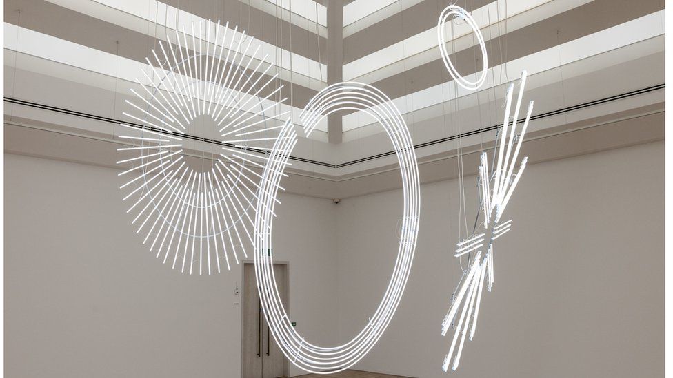 Picture of the art work - the piece consists of three vast discs made from bright white neon light tubes