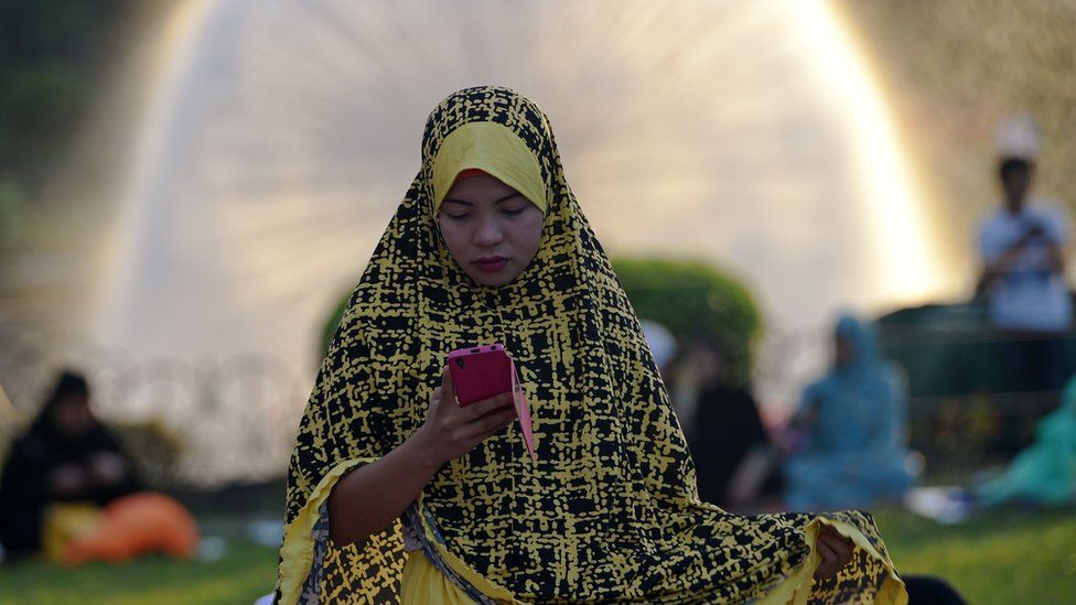 Muislam wa Ufilipino akiwa amevalia vazi la rangi ya manjano na nyeusi kabla ya ibada