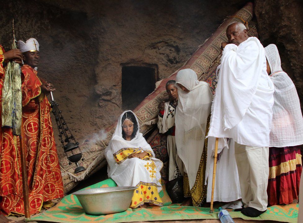 Baptism in a church in Lalibela, priests presiding on the left