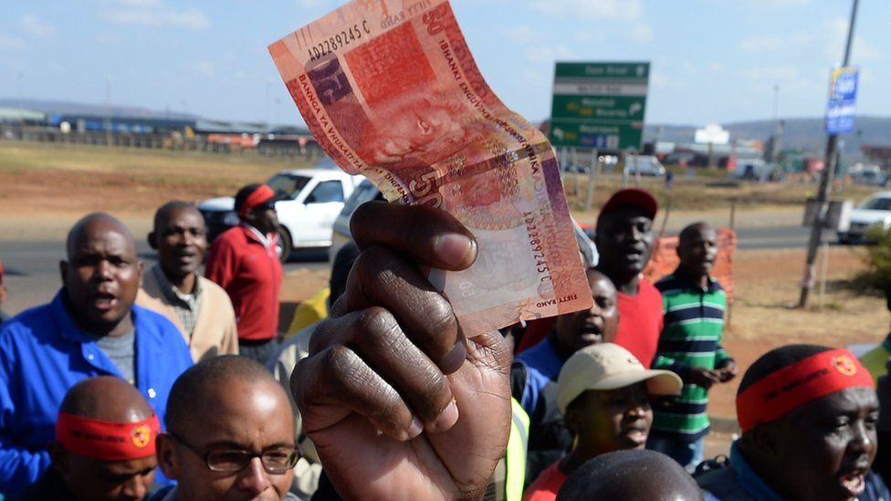 Someone holding a rand not in South Africa - archive shot