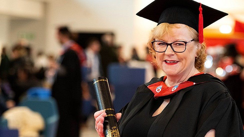 Michelle Lomas in her cap and graduation gown after graduating