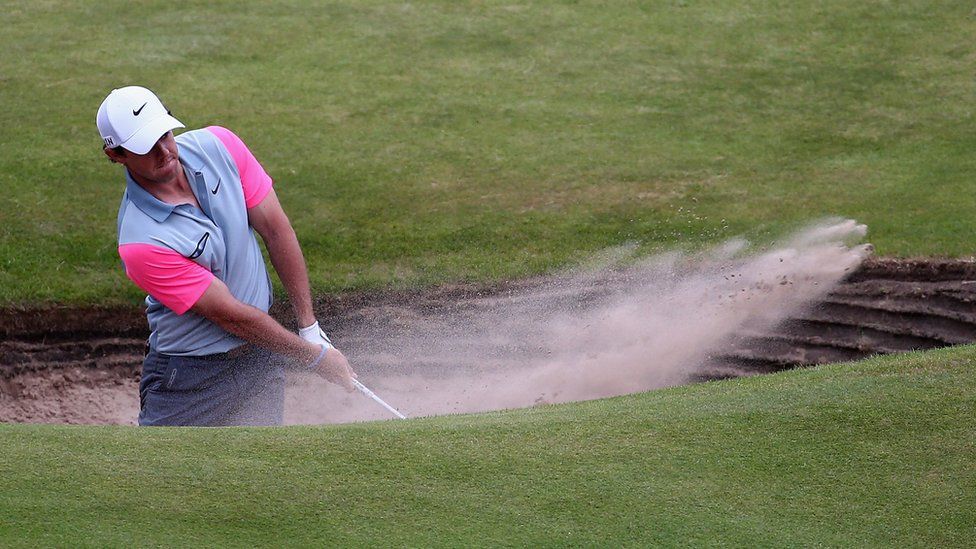 rory mcilroy trys to hit ball in sand pit