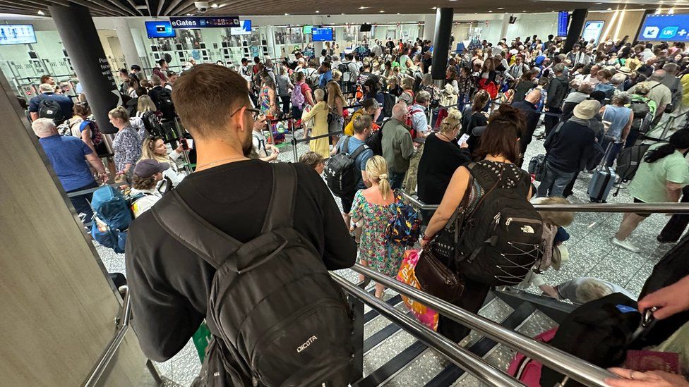 Man waits in queue at passport control at Bristol Airport