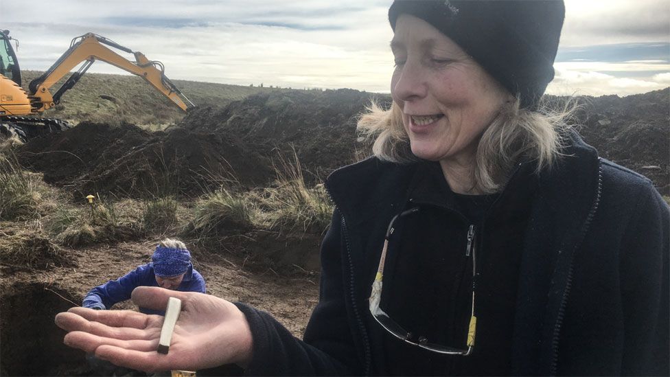 Meg Sinclair, an experienced volunteer archaeologist, and the whetstone