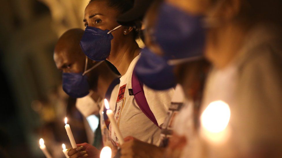 Black movement activists hold candles as they protest against racism and police violence in Rio de Janeiro