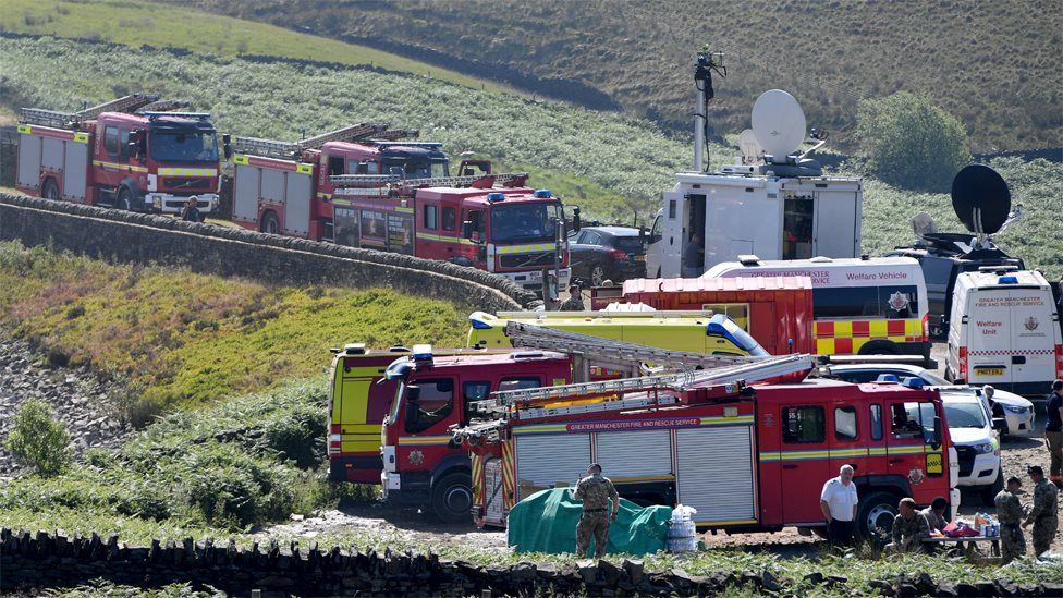 Fire engines park up on the moor as firefighters continue tackling a blaze on Saddleworth Moor