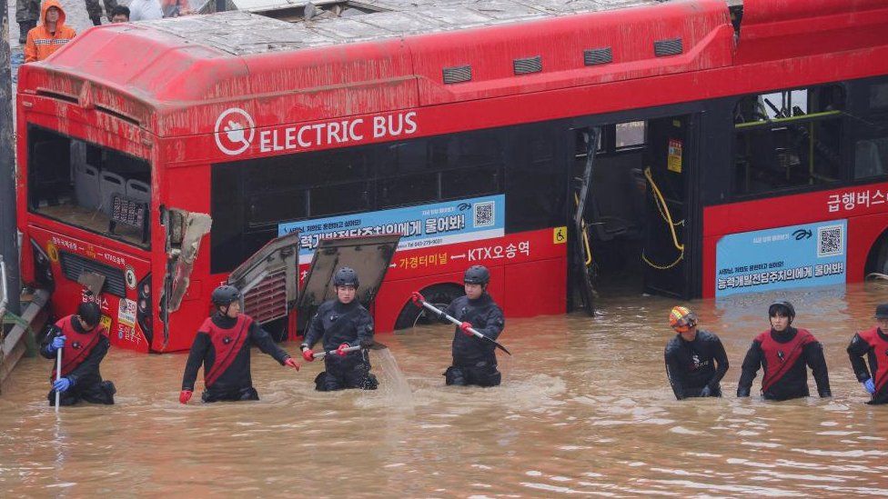 Rescue workers pictured in front of a bus take part in a search and rescue operation near a tunnel