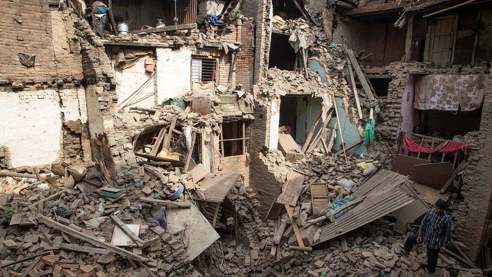 A man stands on top of debris from collapsed buildings on April 26, 2015 in Bhaktapur, Nepal