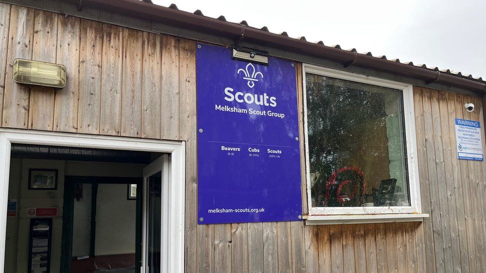 A view of the front of the Melksham Scout Hut with a purple sign including the scouts brand