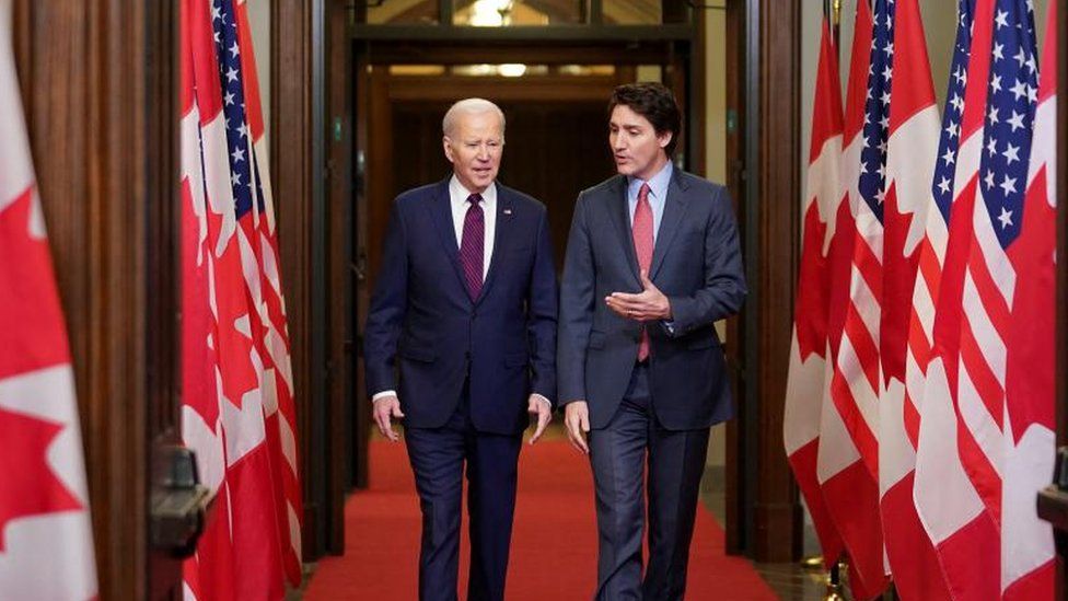 U.S. President Joe Biden walks with Canadian Prime Minister Justin Trudeau as he attends a welcome ceremony in Ottawa, Ontario, Canada
