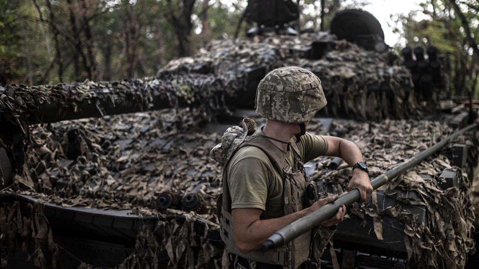Ukrainian soldiers conduct maintenance on a tank in the Bakhmut frontline on 24 July 2023