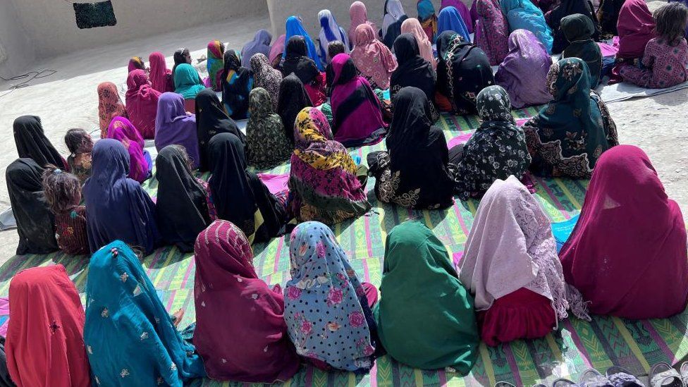 A group Afghan girls sitting on the floor at school