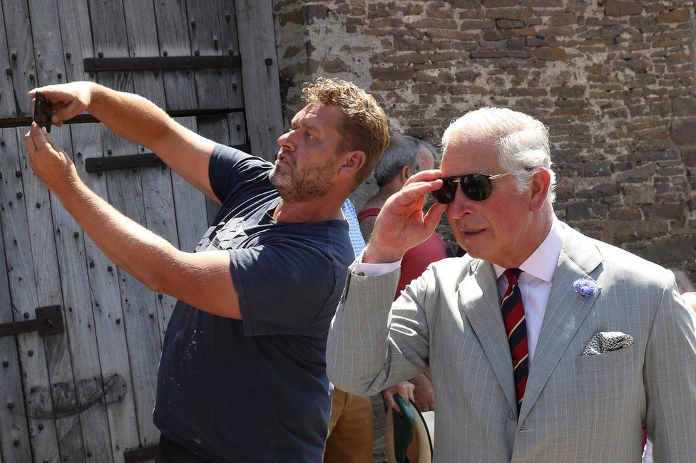 A member of the public takes a selfie with Prince Charles