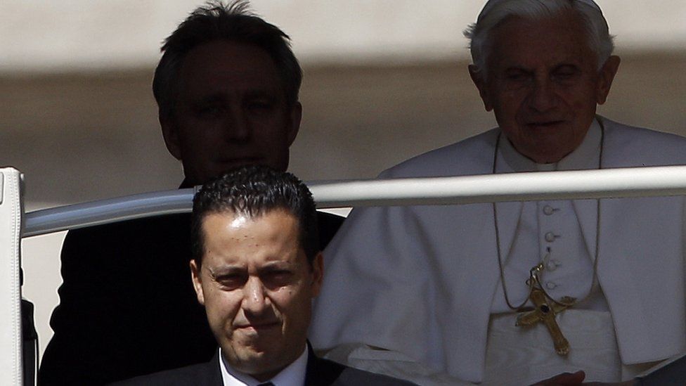 Paolo Gabriele (L) was given an 18-month jail sentence but was pardoned by Pope Benedict (background)