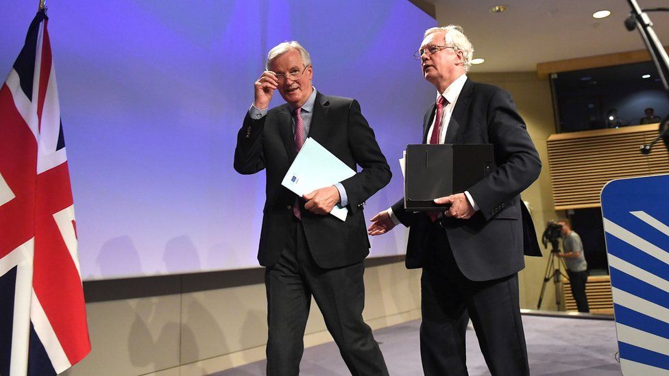 David Davis and Michel Barnier leave the stage after a press conference.