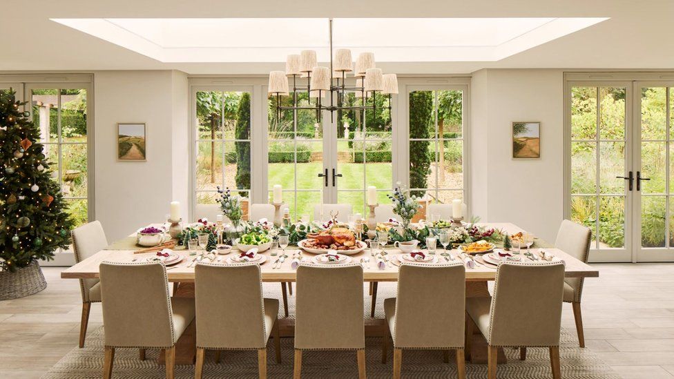 Ornate dining room looking out through French windows on to immaculate lawn