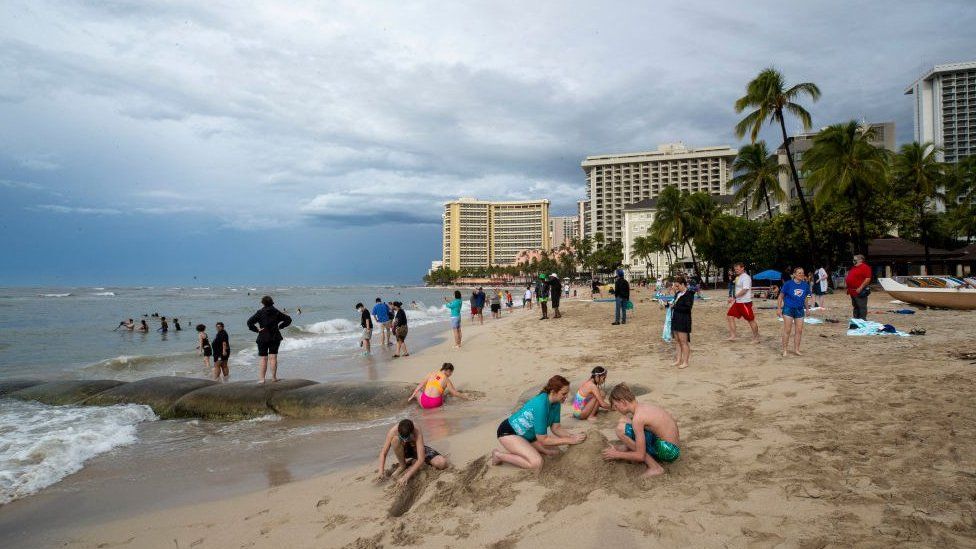 Посетители играют на пляже Вайкики в Гонолулу, Гавайи, 7 декабря 2021 г.