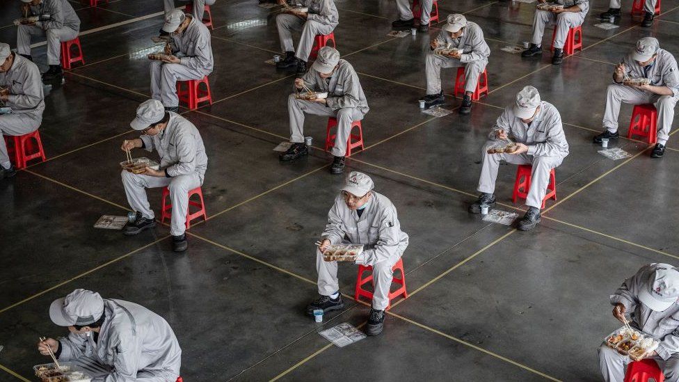 Workers eating during lunch break at the Dongfeng Honda plant in Wuhan in China's central Hubei province