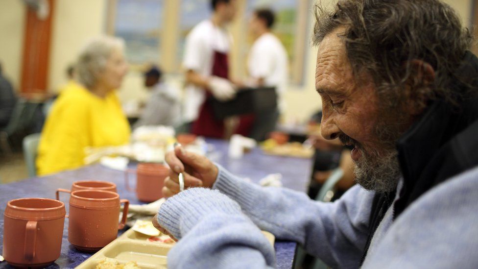 A homeless man eats in a soup kitchen in San Francisco