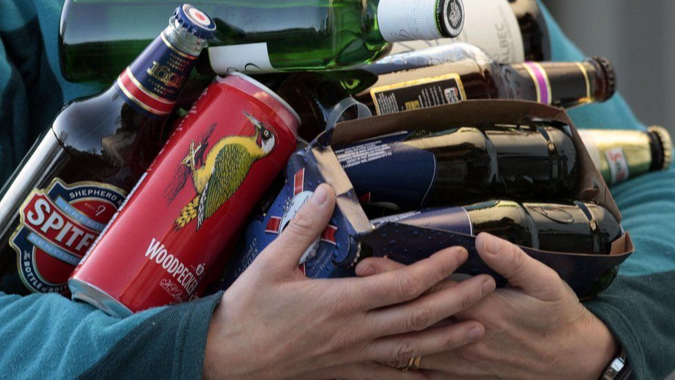 A man carrying different alcoholic drinks.