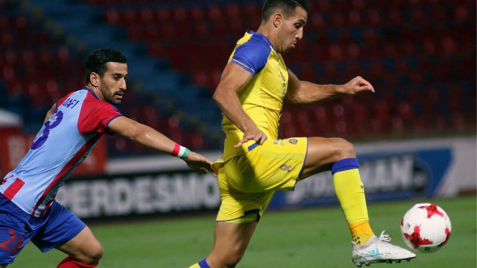 Panionios' Ehsan Hajsafi (L) vies for the ball with Tel Aviv's Eyal Golasa