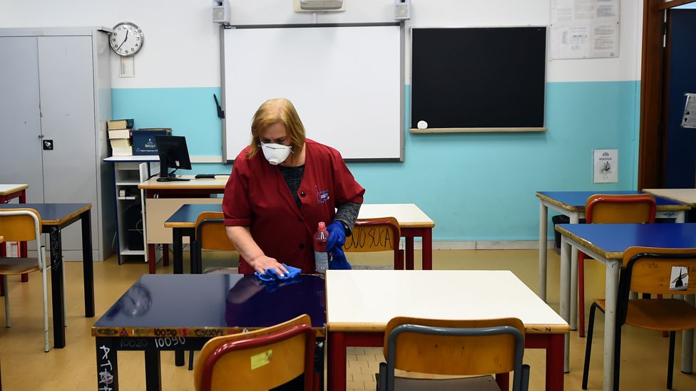 Cleaner in empty classroom in Turin, 2 Mar 20