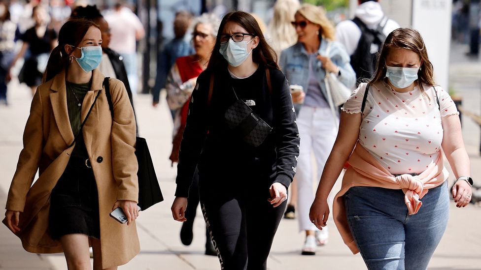Pedestrians wearing face masks walk along Oxford Street in London
