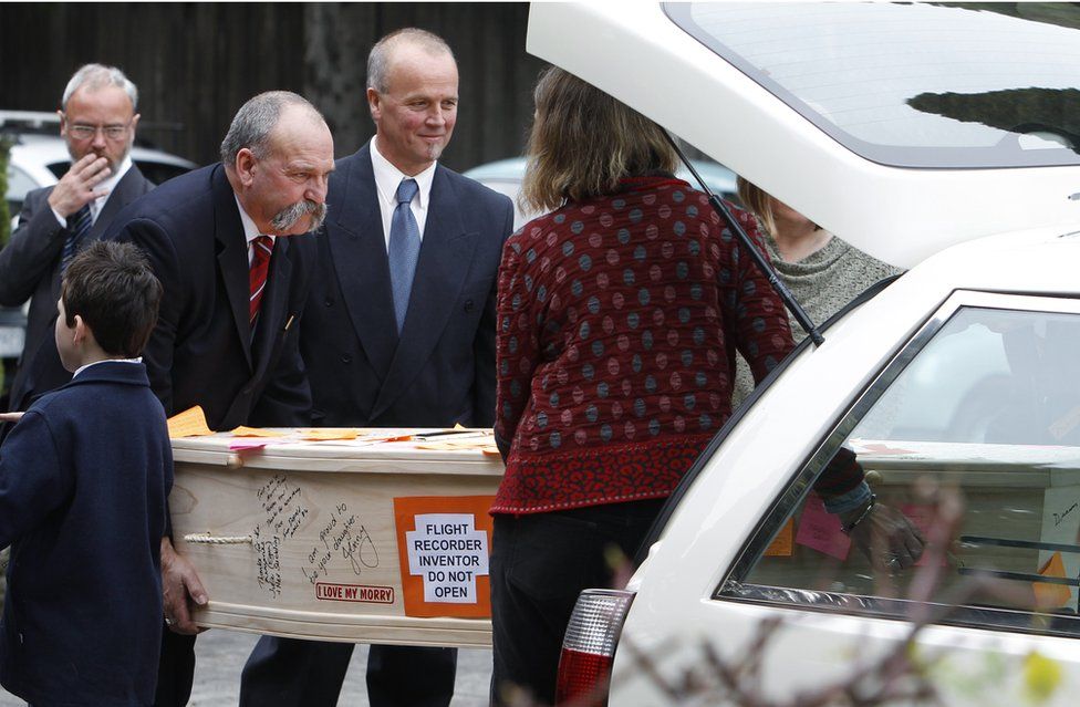 Family members carry the coffin of scientist David Warren at his funeral in Melbourne July 23, 2010.