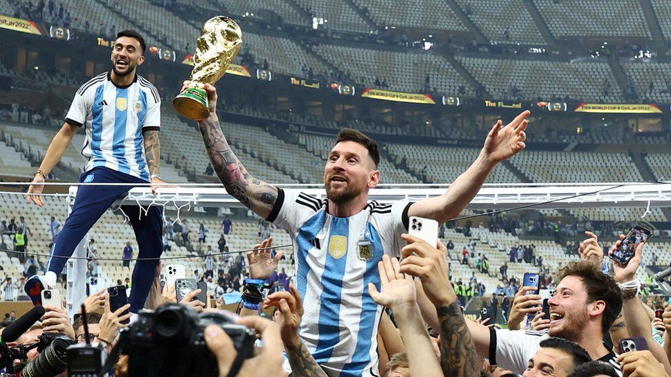 Lionel Messi celebrates with the trophy after winning the World Cup