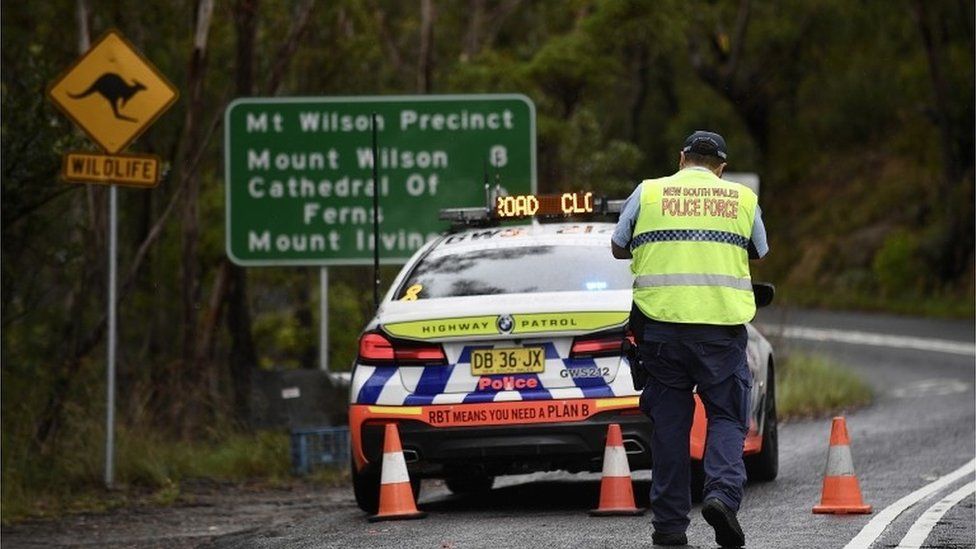 A police officer and vehicle set up a roadblock in the Blue Mountains near Sydney