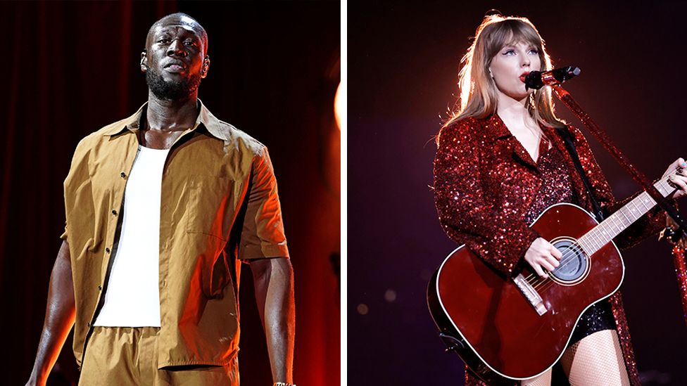 Composite image of Stormzy on the left and Taylor Swift on the right, with a white line in the middle dividing the two imags. Stormzy is wearing a mustard coloured half top and trousers, with a white vest. He is looking at the camera, with the background darkened out. Taylor is wearing a glittery red outfit, playing a red guitar as she sings into a microphone. The background is darkened out with a light shining on Taylor behind her.