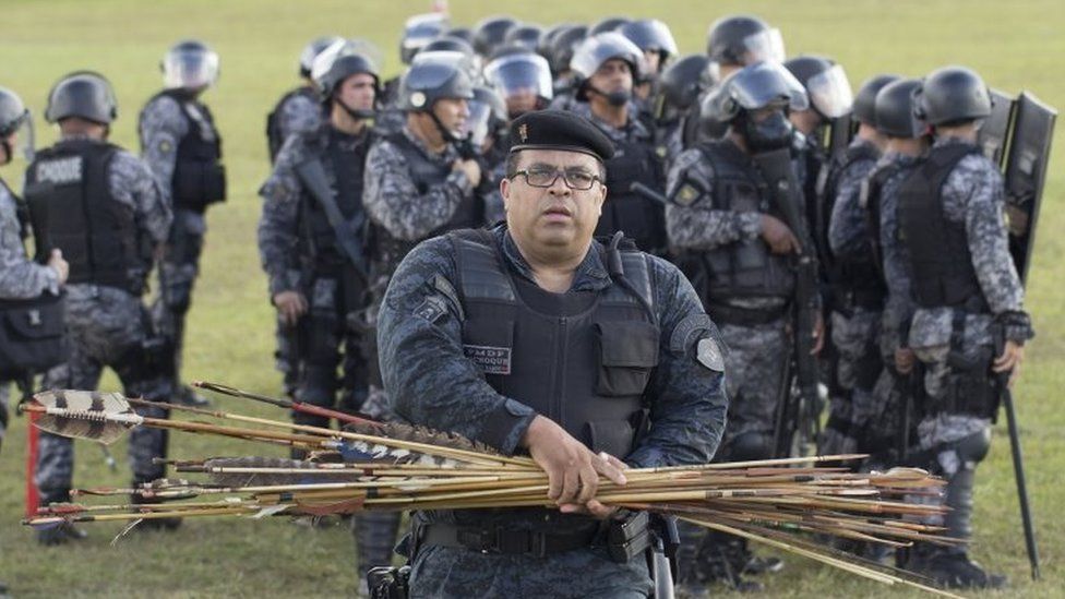 A member of the Brazilian police gathers arrows fired by Brazilian natives during a protest at Explanada dos Ministerios in Brasilia, Brazil, on 25 April 2017