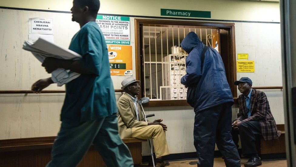 Men wait for medicines at a pharmacy at Parirenyatwa Hospital in Harare, September 2019