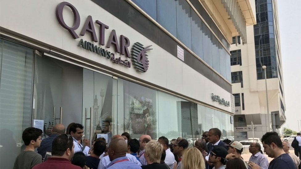 People gather outside a branch of Qatar Airways in the United Arab Emirate of Abu Dhabi on June 6, 2017