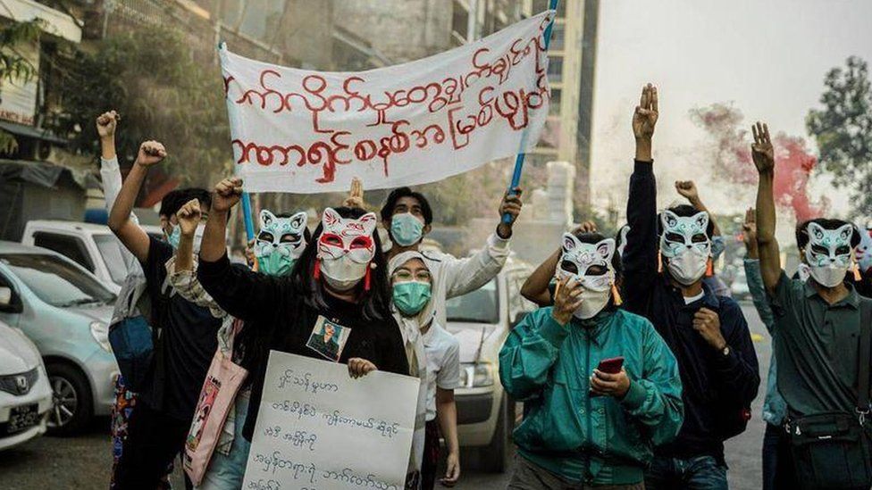 Молодые протестующие в Янгоне носят кошачьи маски, чтобы замаскироваться с