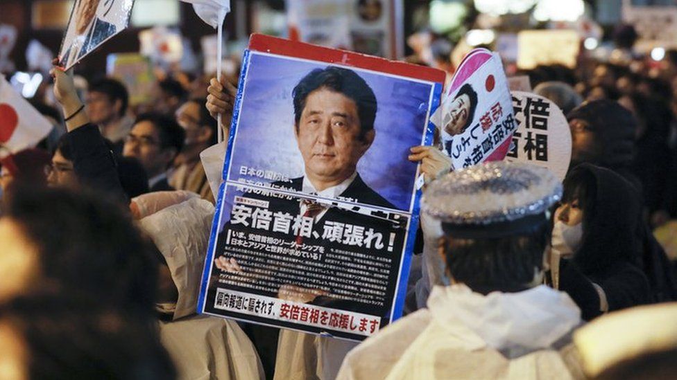 A voter supporting Japanese Prime Minister Shinzo Abe and his ruling Liberal Democratic Party raises a placard reading "Go, Prime Minister Abe" during Abe's final campaign of the Lower House election outside Akihabara JR Station in Tokyo, Japan, 21 October