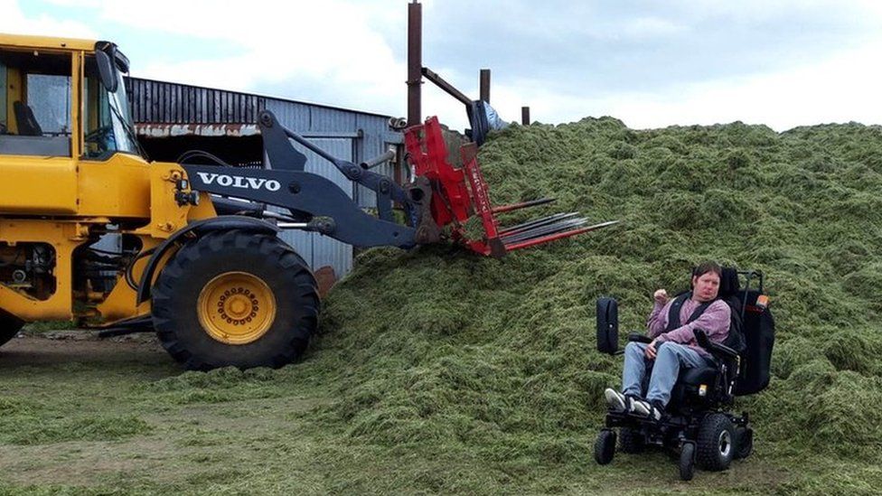 Jonathan Turtle in his wheelchair beside a silage pit