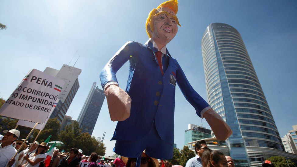 A woman carries an effigy of US President Donald Trump during a march in Mexico City against the proposed border wall, 12 February 2017
