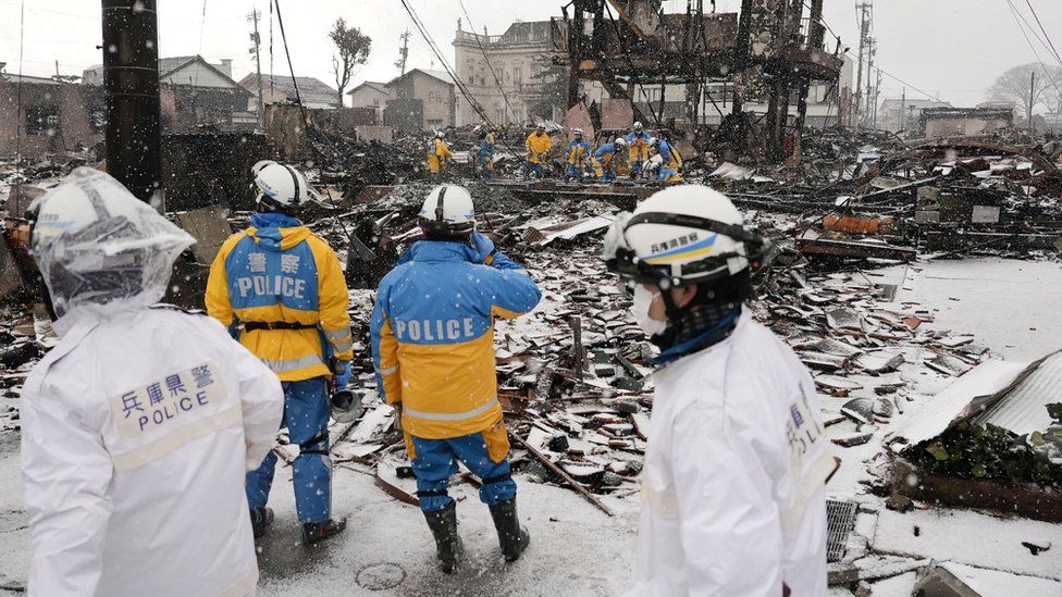 Police officers search for victims of the recent earthquake in Japan