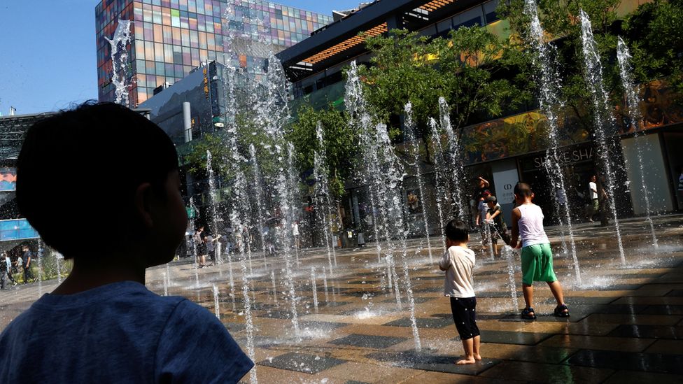 Children seek relief from the heat a public fountain in Beijing on 22 June 2023