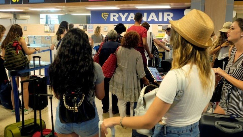 Passengers queue for a Ryanair flight