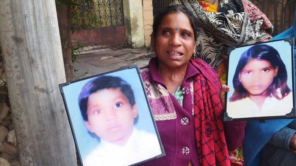 Neetu Kumari holds up photos of her two missing children