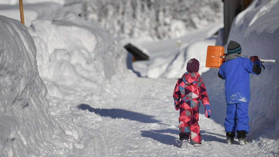 Children walk along a snow covered road in Gerold, Germany, 11 January 2019