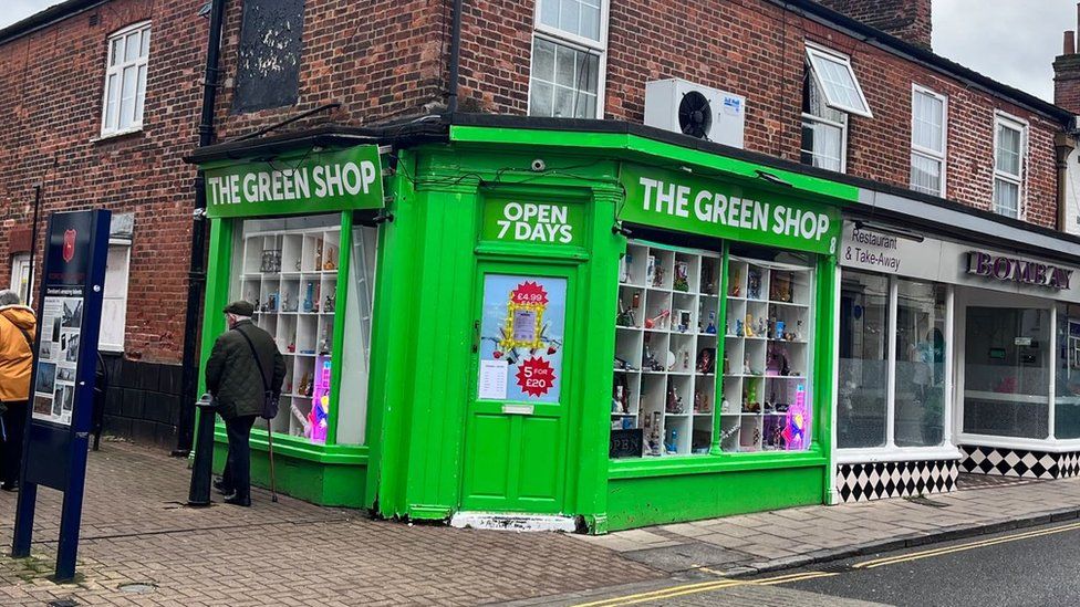 The Green shop in Dereham- a green painting building displaying various vaping products.