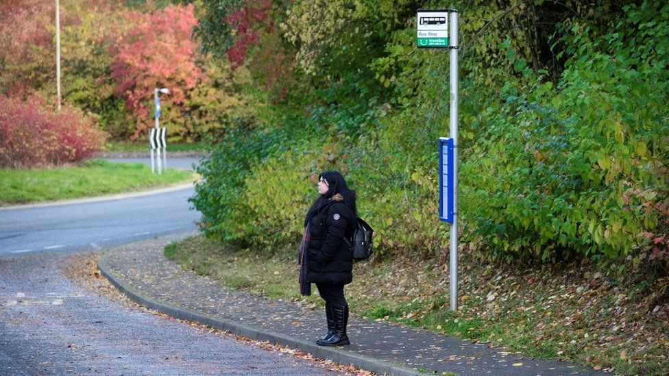 Robin Christie Clarke waiting at an isolated bus stop