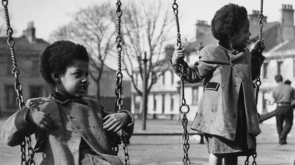 Children on swings in the old Tiger Bay