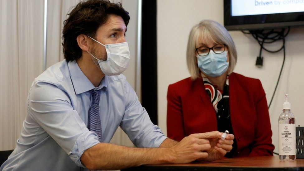 Canada's Prime Minister Justin Trudeau holds an empty Covid-19 vaccine vial
