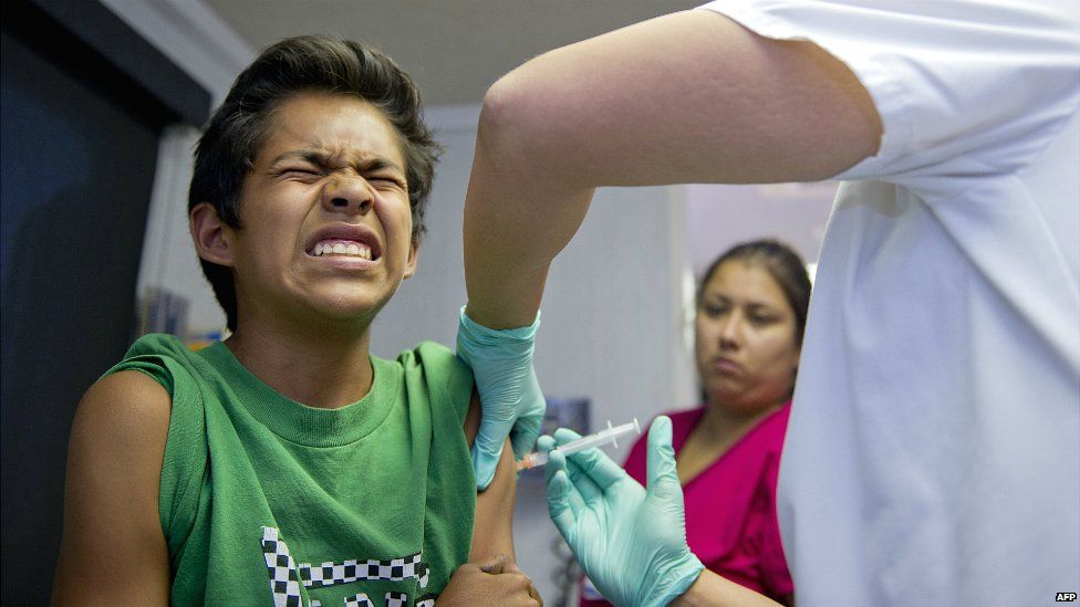 A public school student grimaces as he gets a vaccination at a clinic for students in Lynwood, California - 27 August 2013